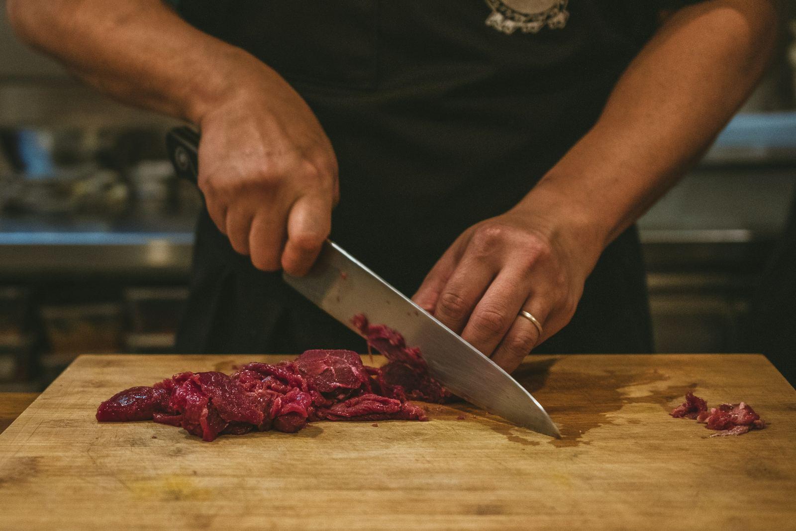 A butcher breaking down a cut of beef